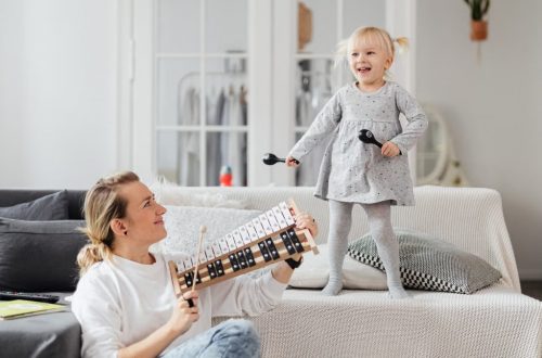 A mother and daughter bond through music at home, playing joyful melodies.