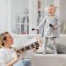 A mother and daughter bond through music at home, playing joyful melodies.